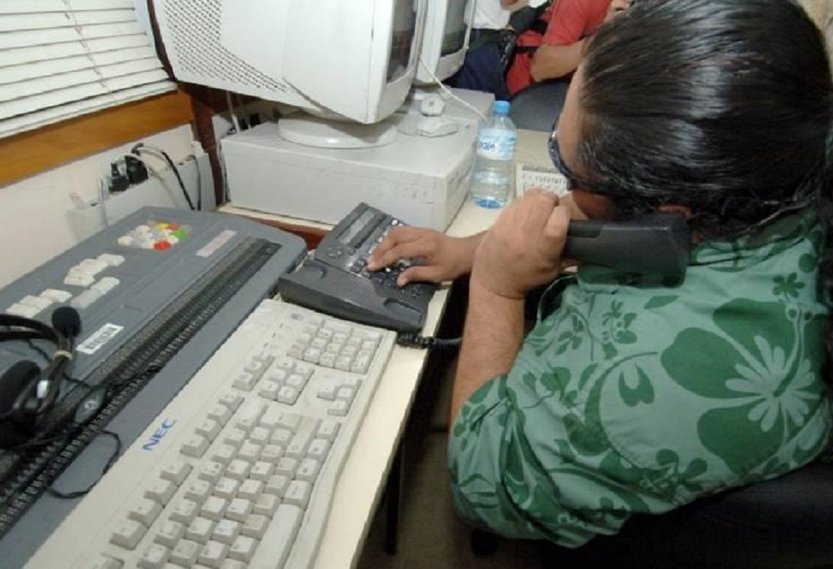 Une Standardiste Non Voyante disposant de different telephone et clavier en braille