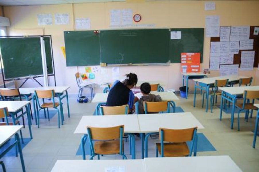 un enfant aupres d une avs dans une classe dans la banlieux parisienne