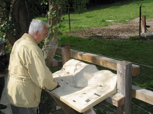 un non voyant en randonnee lisant une pancarte en Braille