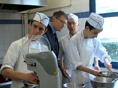 Vincent PEILLON lors de sa visite dans le lycée professionnel au coté d'élèves et d'un professeur