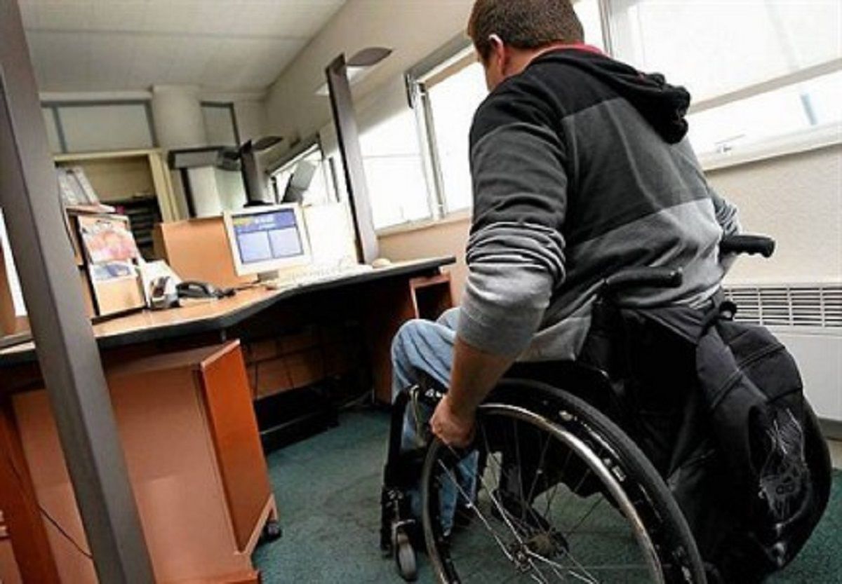 une personne en fauteuil dans un bureau sur son lieu de travail